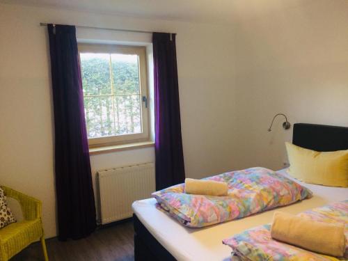 een slaapkamer met 2 bedden en een raam bij Appartements Luxner in Achenkirch