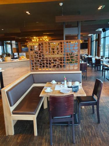 a dining room with a wooden table and chairs at Hotel Hafenresidenz Stralsund in Stralsund