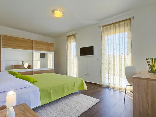 1 dormitorio con 1 cama verde y TV en Villa Lungera, en Štinjan