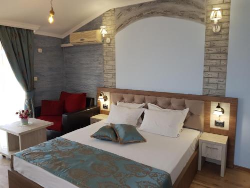 a bedroom with a large bed and a red couch at Vromos Guest Rooms in Chernomorets