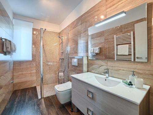 Un baño con lavabo, inodoro y ducha. en Villa Lungera, en Štinjan