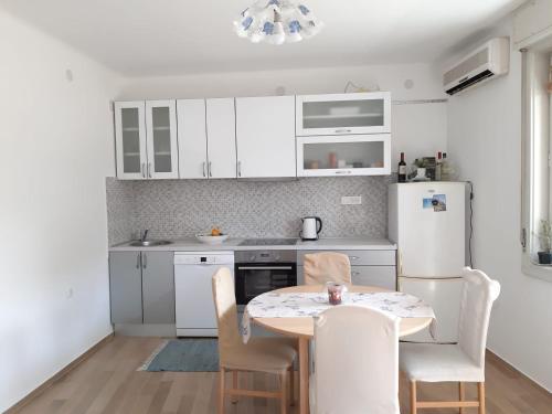una cucina con tavolo, sedie e frigorifero di Nina, apartment in city centre a Spalato (Split)