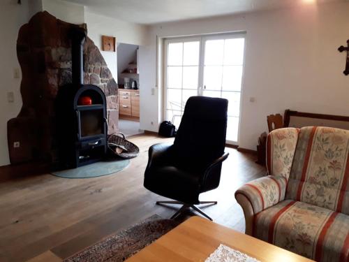 ein Wohnzimmer mit einem Stuhl und einem Kamin in der Unterkunft Ferienwohnung Farrenkopf in Hambrunn