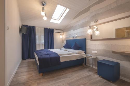 a bedroom with a blue bed and a window at SCHLOSSHOF SÜDTIROL - Hotel & Camping Resort in Lana