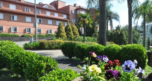 a garden with flowers in front of a building at Farina Park Hotel in Bento Gonçalves