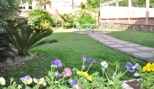 a garden with purple and yellow flowers in the grass at Farina Park Hotel in Bento Gonçalves