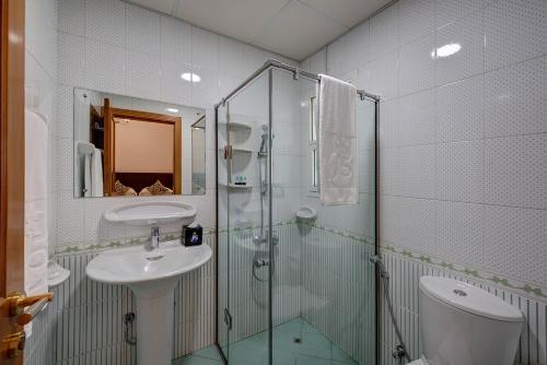 J5 Four Bedroom Villa Holiday home in Mirdif في دبي: حمام مع دش زجاجي ومغسلة