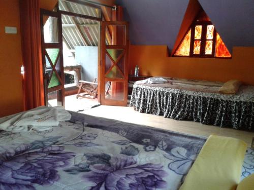 a room with two beds in a room with a window at King Fern Cottage in Nuwara Eliya