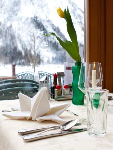 a table with a candle and a vase with a flower at Hotel Klingler in Maurach