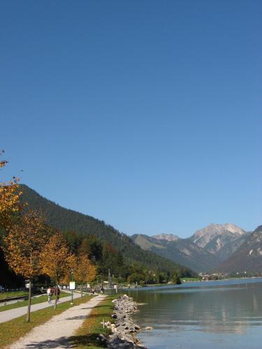 a path next to a lake with mountains in the background at Hotel Klingler in Maurach