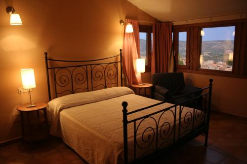 a bedroom with a bed and a chair and a window at Casas Rurales El Parador in Letur