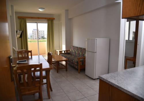 a kitchen and living room with a couch and a refrigerator at Elysso Apartments in Larnaca