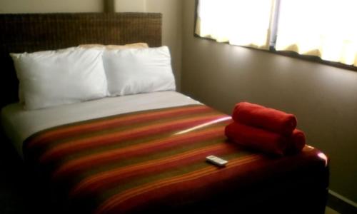 a bed in a hotel room with a red towel at Vistazul Rentals in San Clemente