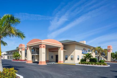 a hotel with a palm tree in front of it at Baymont by Wyndham Punta Gorda/Port Charlotte in Punta Gorda