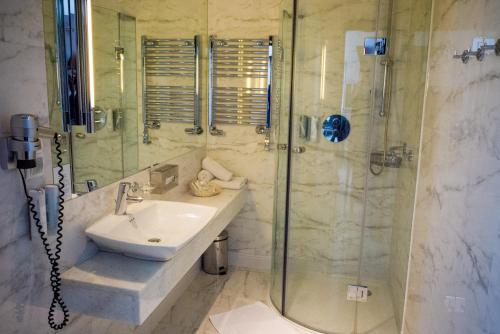 a bathroom with a sink and a shower at Hotel Krasicki in Lidzbark Warmiński