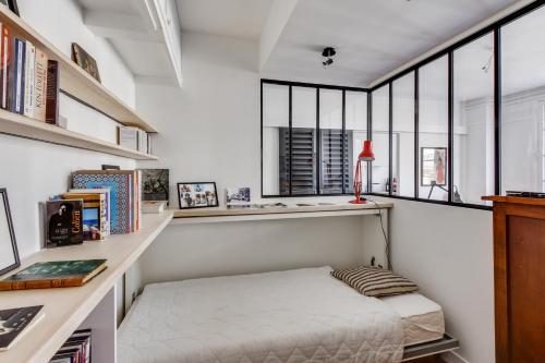 um quarto com uma cama e uma secretária com janelas em Design apartment with terrace by Weekome em Paris