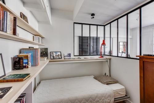 Cette chambre comprend un lit et un bureau avec des fenêtres. dans l'établissement Design apartment with terrace by Weekome, à Paris