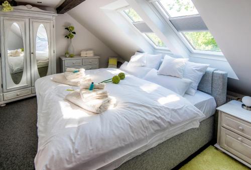 ein Schlafzimmer mit einem großen weißen Bett mit Handtüchern darauf in der Unterkunft Landhaus Alte Apotheke in Großefehn 