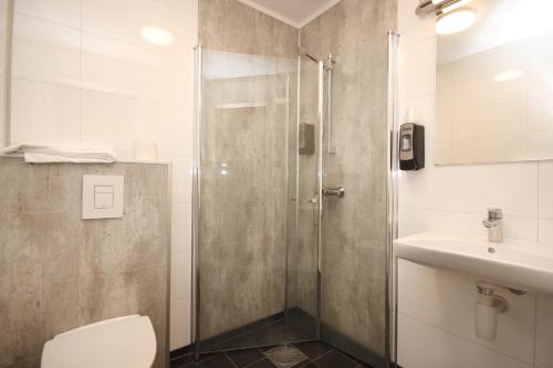 y baño con ducha, aseo y lavamanos. en Napoli Resturant & Hotell AS, en Sandnessjøen