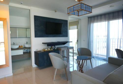 a kitchen and living room with a table and chairs at Grande Albergo Marin in Lignano Sabbiadoro