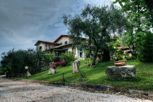 a house with a yard with rocks in front of it at B&B Villa Miramì in Saturnia