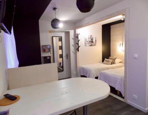 a room with two beds and a table and a mirror at Barcelo Appart'hotel in Barcelonnette