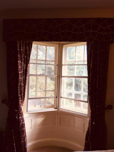 a window in a room with two windows with curtains at Brass Castle Country House Accommodation in Middlesbrough