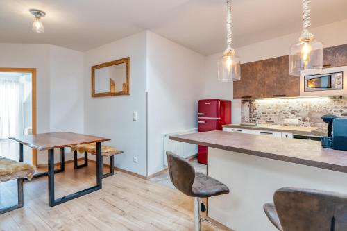 a kitchen with a table and chairs and a red refrigerator at Weingut Gästehaus D&D Haider in Jois