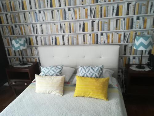 a bedroom with a bed and a wall of books at Hotel Cristo Rei in Porto