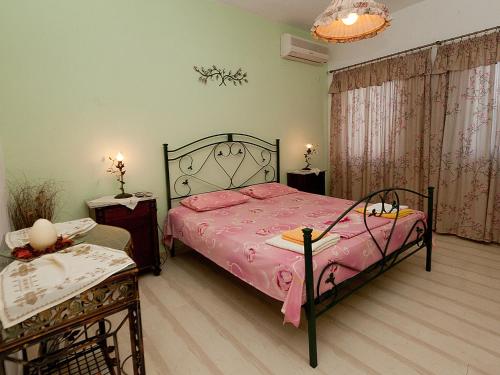 a bedroom with a bed with a pink bedspread at Sweet Memories Beach Houses in Mesongi