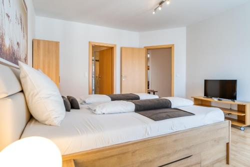 a bedroom with a large white bed with white pillows at Weingut Gästehaus D&D Haider in Jois