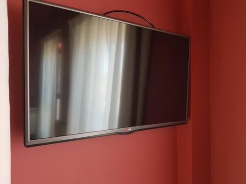 a flat screen tv hanging on a red wall at Hotel Las Murallas in Avila