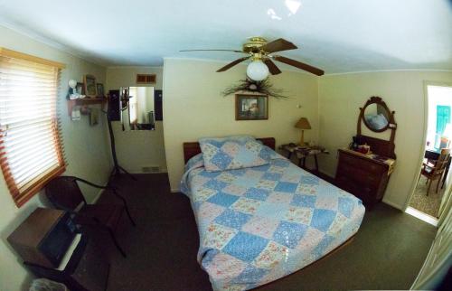 a bedroom with a bed and a ceiling fan at Oak Park Inn in Whitehall