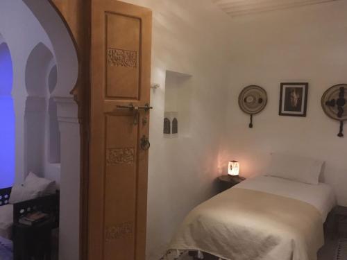 a bedroom with a bed and an open door at Dar 23 in Tangier