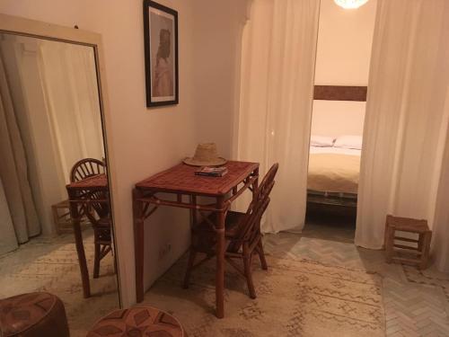 a small table and chairs in a room with a bed at Dar 23 in Tangier