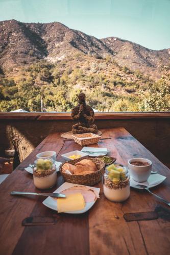una mesa con comida y vistas a la montaña en Biosfera Lodge, en Olmué