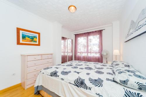 una camera bianca con un letto e una finestra di ALEGRIA ID106 a Torrevieja