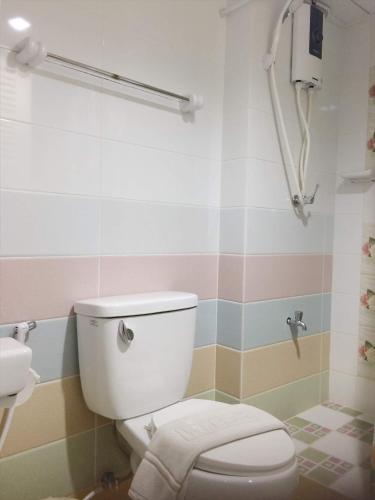 a bathroom with a toilet and a sink at Changpuak Hotel in Chiang Mai
