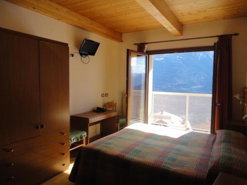 a bedroom with a bed and a large window at Albergo Ristorante Baraglia in Mello