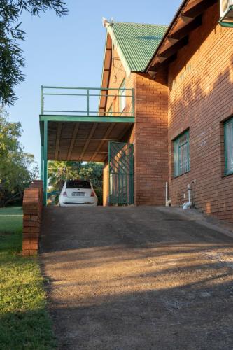 a house with a car parked in the garage at Olive Tree Farm in Magaliesburg