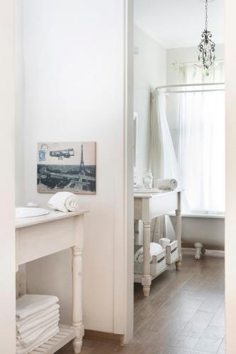 a white bathroom with a sink and a mirror at Casa Chacabuco Tandil in Tandil