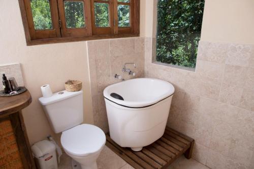 a bathroom with a white toilet and a sink at Chalé Solar no Matutu in Aiuruoca