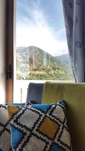 a couch with a pillow and a window with a view at Lefteris Rooms in Kámbos