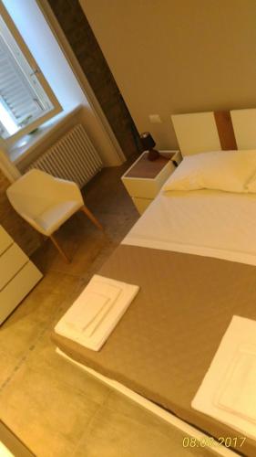 a hotel room with a bed and a chair at B&B Dimora Damiani in Montefiore dellʼAso