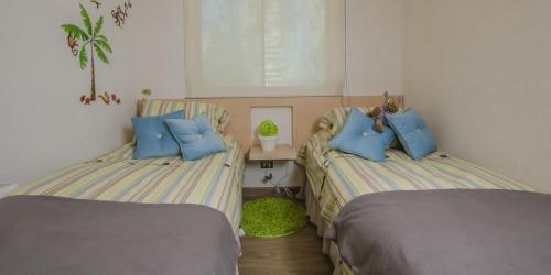 a bedroom with two beds with blue pillows at Departamento en Viña del Mar in Viña del Mar