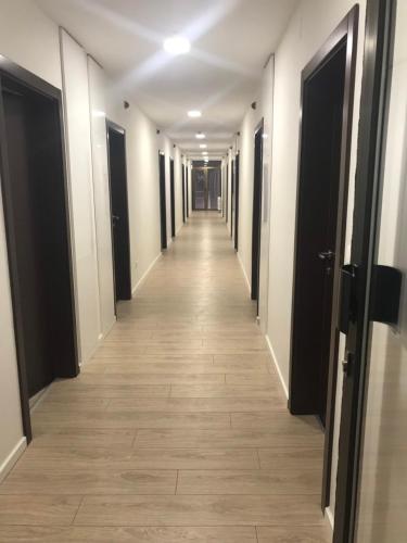 a long hallway with black doors and a tile floor at Hotel Grand in Sarajevo