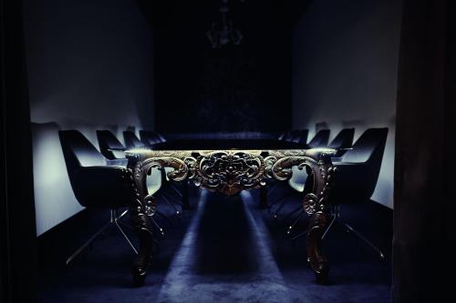 a table and chairs in a dark room at Hotel Krasicki in Lidzbark Warmiński