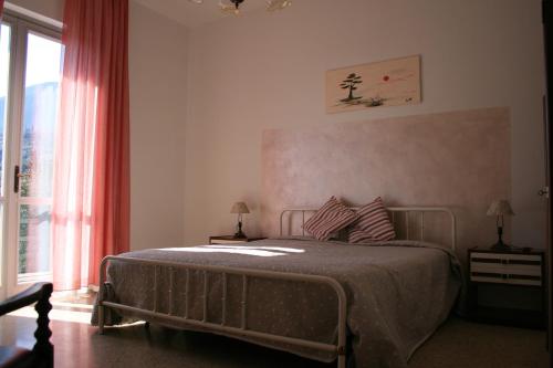 a bedroom with a bed and a large window at La terrazza sugli ulivi in Toscolano Maderno
