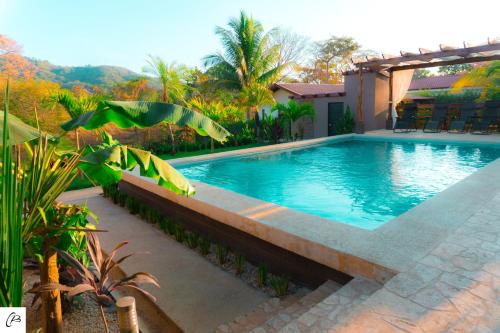a swimming pool in front of a house at Hotel Casa Buenavista - Adults only in Sámara