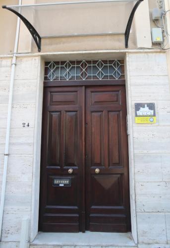 a large wooden door in a white building at La casa di Luce in Reggio Calabria
